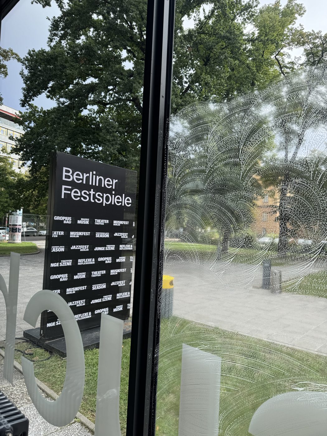 Reinigung einer großen Glasfront – eingeschäumte Scheibe neben bereits sauberer Scheibe